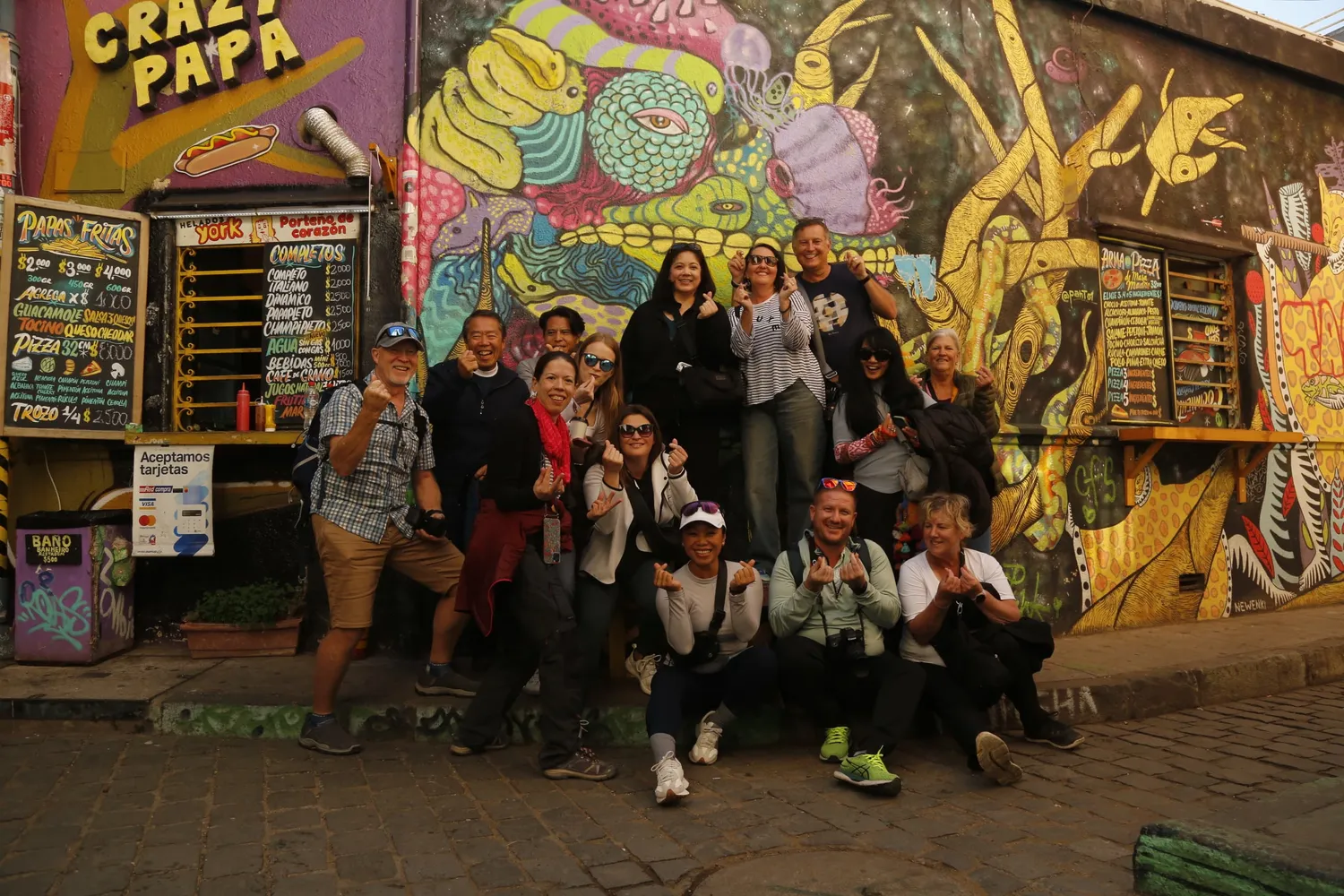 A group looking at a large mural with their guide in Valparaiso