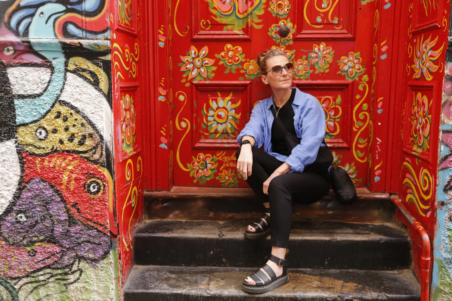 A traveler in front of a detailed mural in Valparaiso